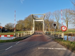 
                            <b>Traditionele ophaalbrug met slagbomen en verkeersborden in landelijke omgeving.</b><br>
                                                        <b>ISO:</b> 50 | <b>Sluitertijd:</b> 1/4926 | <b>Diafragma:</b> f/1.8 | <b>Datum:</b> 2025-03-09

                        