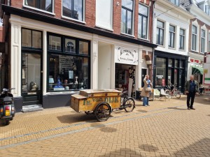 
                            <b>Oude bakfiets geparkeerd voor winkel met kijkende mensen op straat.</b><br>
                                                        <b>ISO:</b> 50 | <b>Sluitertijd:</b> 1/6757 | <b>Diafragma:</b> f/1.8 | <b>Datum:</b> 2025-05-26

                        