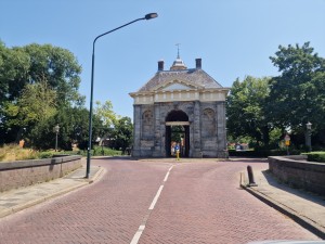 
                            <b>Historische Koepoort, geflankeerd door bomen, op de Westeinde.</b><br>
                                                        <b>ISO:</b> 50 | <b>Sluitertijd:</b> 1/944 | <b>Diafragma:</b> f/1.8 | <b>Datum:</b> 2025-07-02

                        