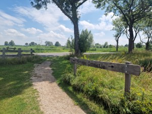 
                            <b>Houten bord wijst naar Groene Ommetje wandelpad langs gras en bomen.</b><br>
                                                        <b>ISO:</b> 50 | <b>Sluitertijd:</b> 1/1255 | <b>Diafragma:</b> f/1.8 | <b>Datum:</b> 2025-07-20

                        