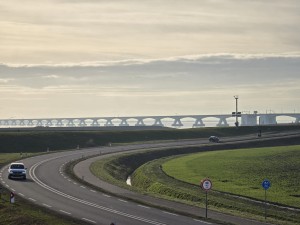 
                            <b>Auto rijdt over kronkelende dijkweg met grote brug op achtergrond.</b><br>
                                                        <b>ISO:</b> 32 | <b>Sluitertijd:</b> 2467/5000000 | <b>Diafragma:</b> f/3.4 | <b>Datum:</b> 2026-02-08

                        