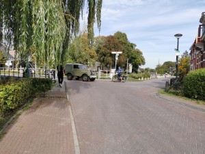 Groene oldtimer terreinwagen rijdt over een ophaalbrug.