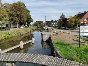 Dorpskanaal met houten steiger en aanlegplaatsen.